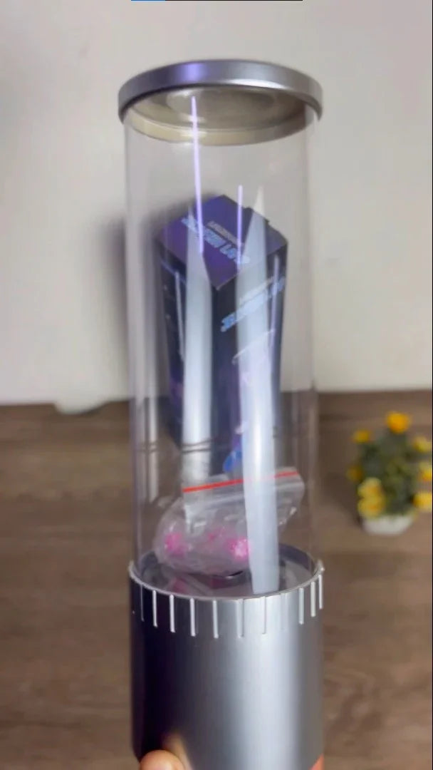 Portable transparent capsule toy dispenser with silver base and purple box inside, on wooden table