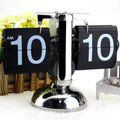 Retro flip clock showing 10:10 AM with chrome stand and decorative yellow flowers background