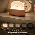 Cute toast-shaped night light with adjustable brightness on bedside table next to clock