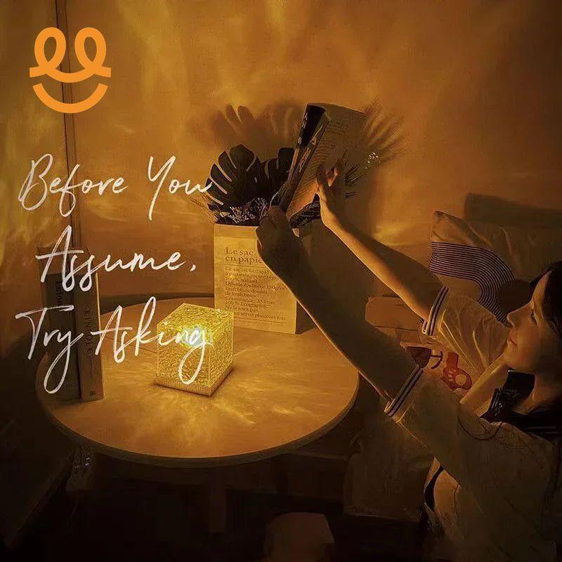 Woman taking photo near glowing decorative cube lamp on round table with plant and books in cozy dim room