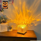 Decorative desk lamp casting golden fiery light patterns on a wooden table with plant and art prints