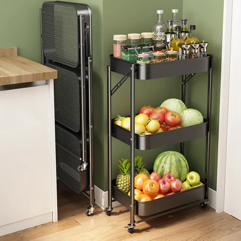 Black metal kitchen cart with three shelves holding fruits, vegetables, and jars against green wall