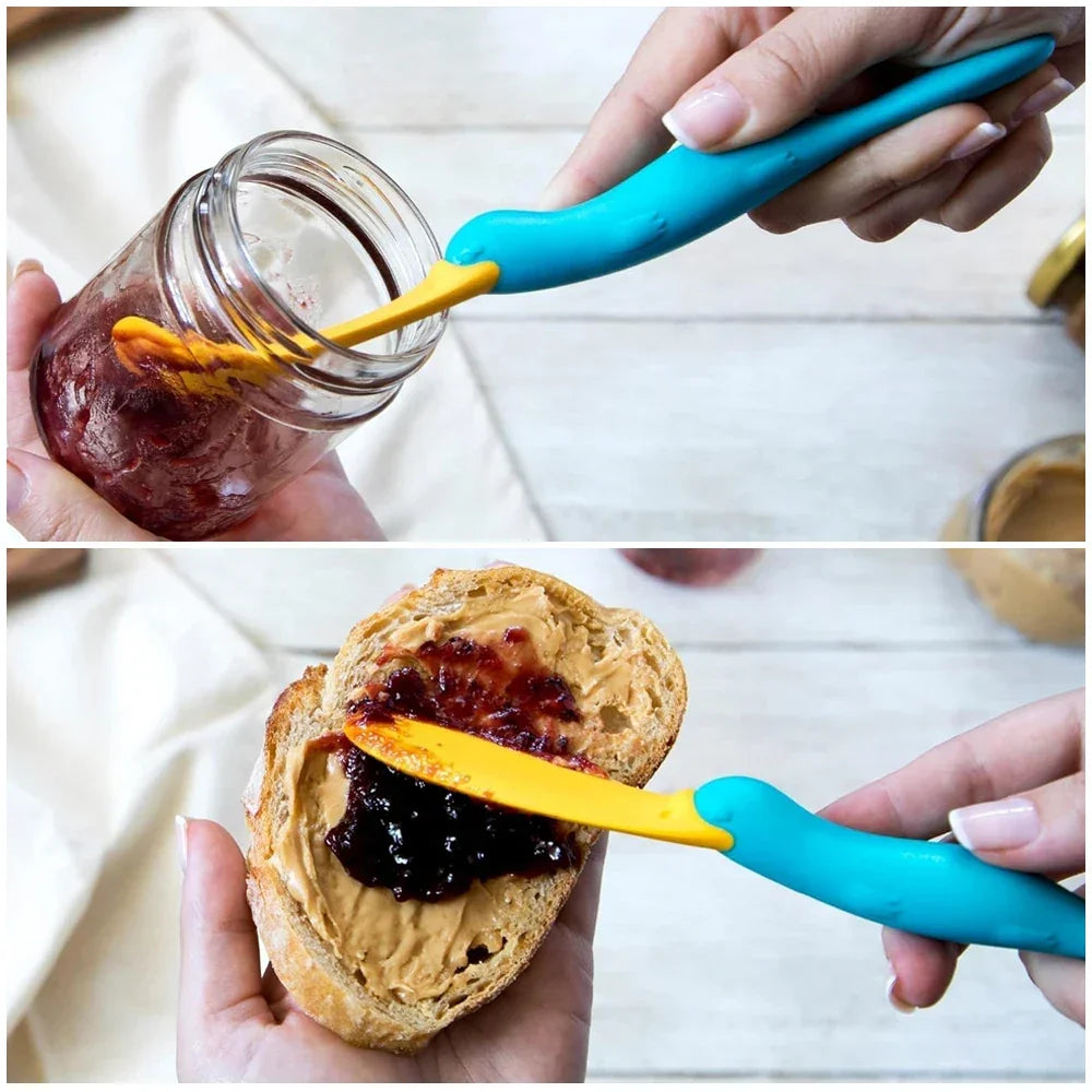 Blue and yellow spreader scooping jam from jar and spreading jam on peanut butter toast