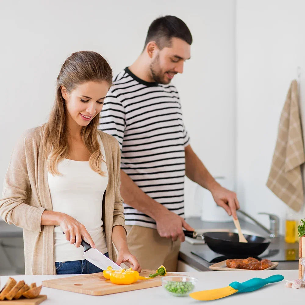 Couple cooking together in contemporary kitchen, woman chopping yellow bell pepper, man stirring pan
