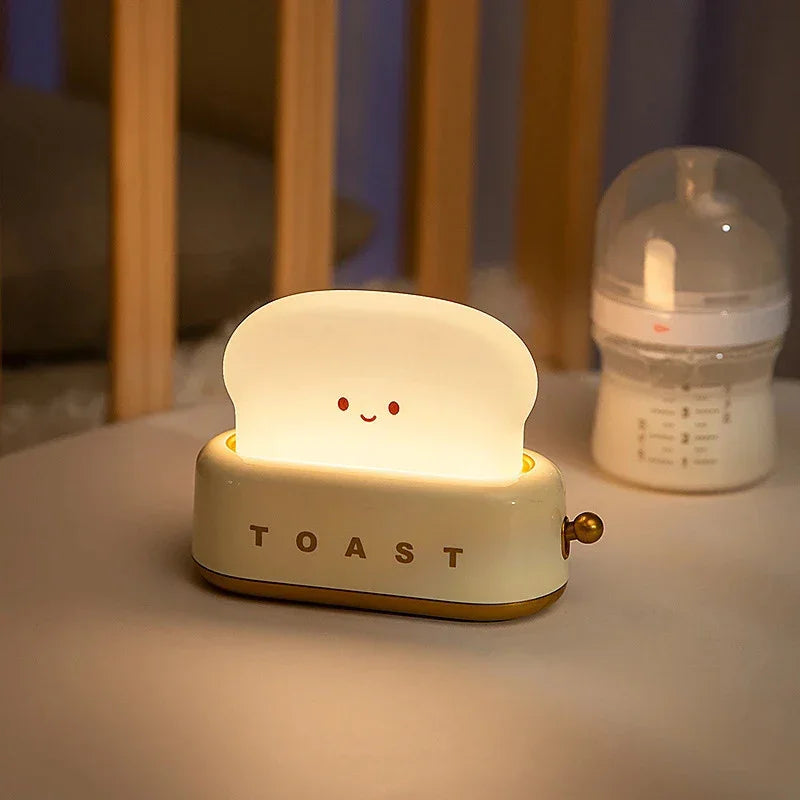 Cute smiling toast-shaped night light on table next to baby bottle in nursery